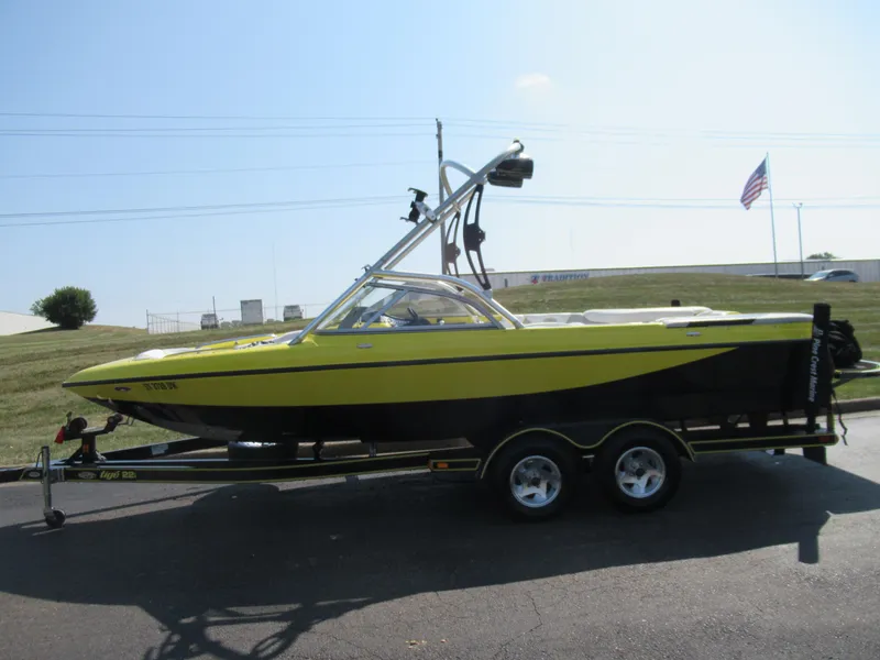 Slide: The Image of 2006 Tigé 22i yellow and black boat on trailer, parked outdoors. - 4