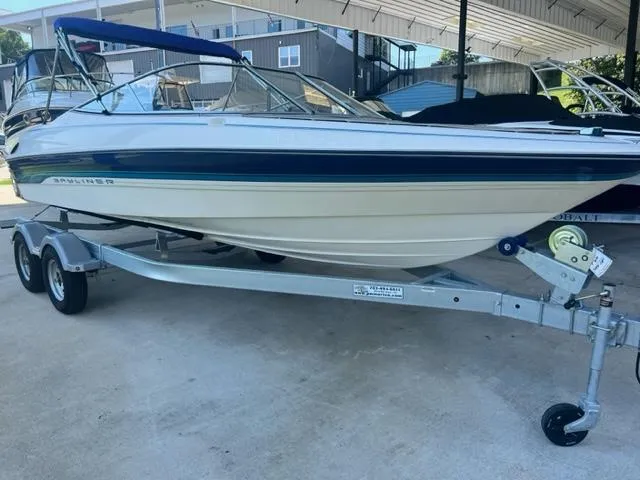 The Image of 1995 Bayliner 2050 Capri boat on trailer, under a covered area. - 0