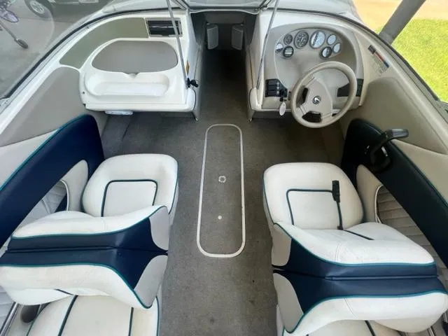 Slide: The Image of Interior of a 1995 Bayliner 2050 Capri boat with white seating and dashboard. - 15