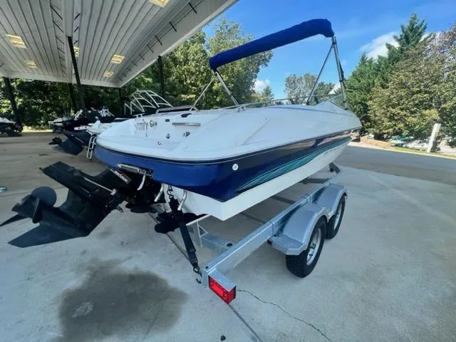 Slide: The Image of 1995 Bayliner 2050 Capri boat on trailer under a canopy, ready for transport. - 3
