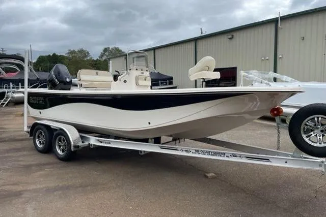 Slide: The Image of 2024 Carolina Skiff 21LS boat on trailer, parked outdoors under cloudy sky. - 8