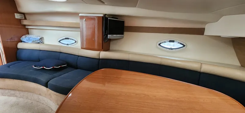 Slide: The Image of Interior of 2006 Maxum 3100 SE yacht with plush seating and wooden table. - 14