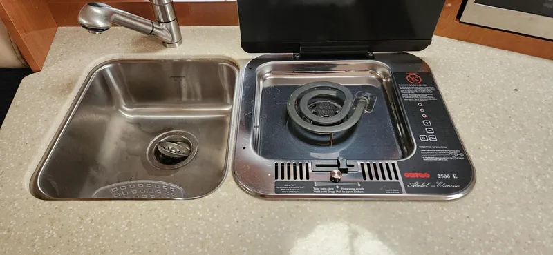 Slide: The Image of 2006 Maxum 3100 SE boat kitchen with sink and electric stove. - 16