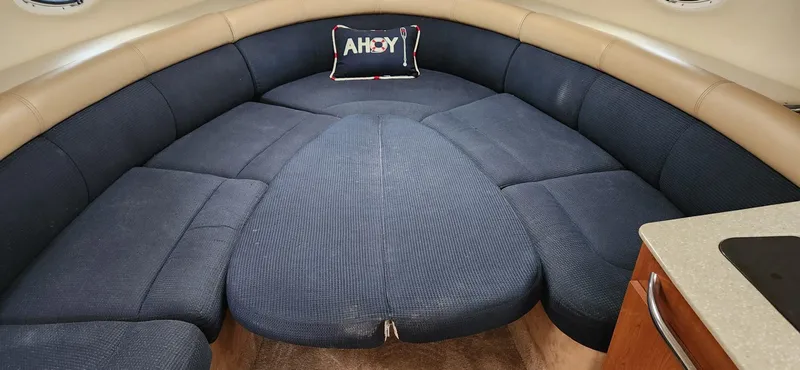 Slide: The Image of 2006 Maxum 3100 SE cabin interior with blue seating and "Ahoy" pillow. - 17