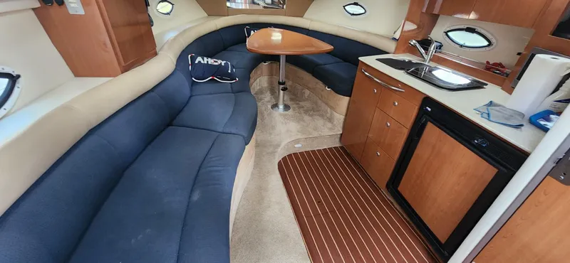 Slide: The Image of Interior of 2006 Maxum 3100 SE boat with blue seating and kitchenette. - 2