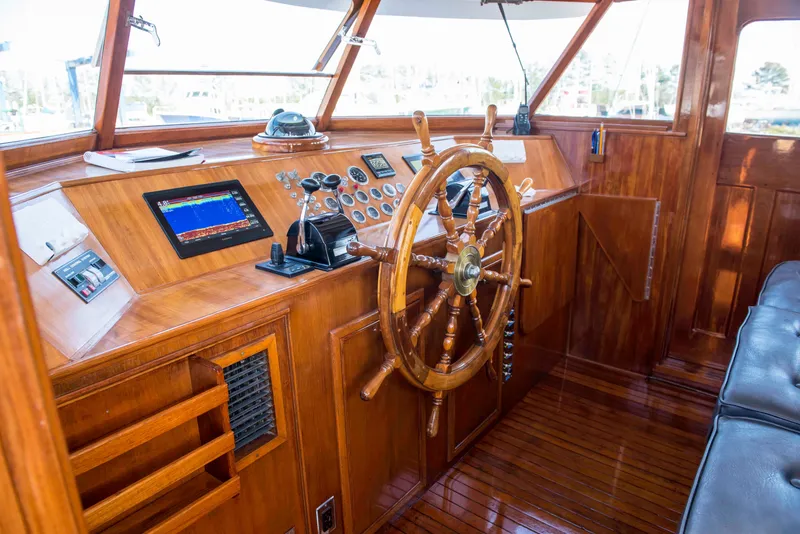 Slide: The Image of 1947 Trumpy Raised Pilot House boat helm with wooden steering wheel and modern navigation equipment. - 10