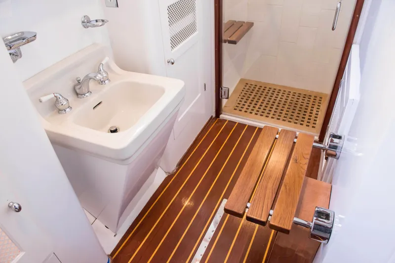 Slide: The Image of 1947 Trumpy Raised Pilot House bathroom with wooden floor and white sink. - 13