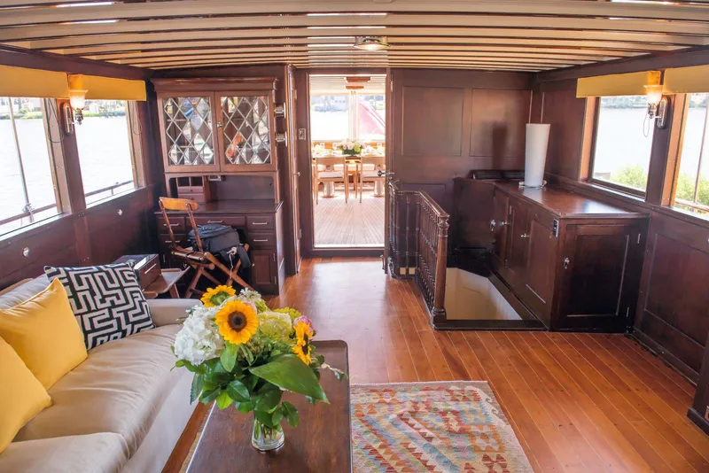 Slide: The Image of Interior of 1947 Trumpy Raised Pilot House with wooden decor and floral arrangement. - 9