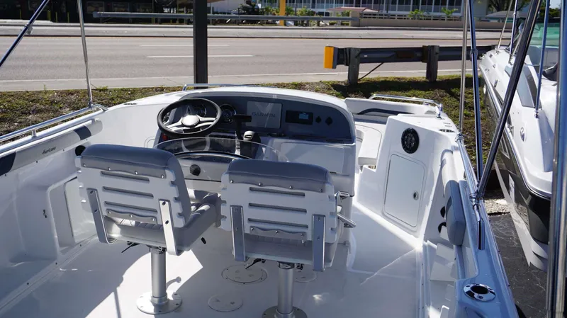 Slide: The Image of 2024 Hurricane 231 SS boat interior with dual captain chairs and Garmin navigation system. - 16