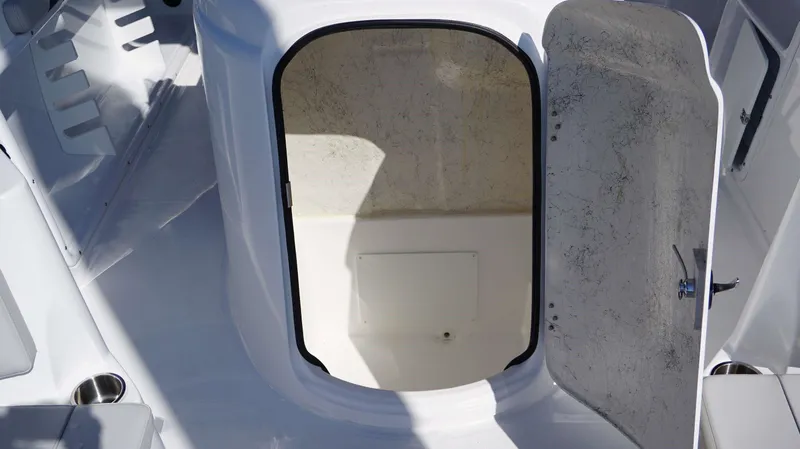 Slide: The Image of 2024 Hurricane 231 SS boat interior storage compartment with open door. - 20