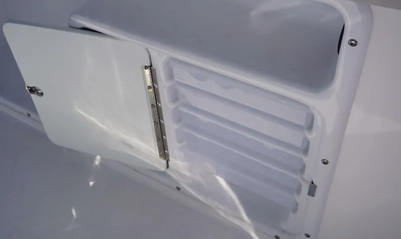 Slide: The Image of 2024 Hurricane 231 SS boat storage compartment with open door and multiple trays. - 6