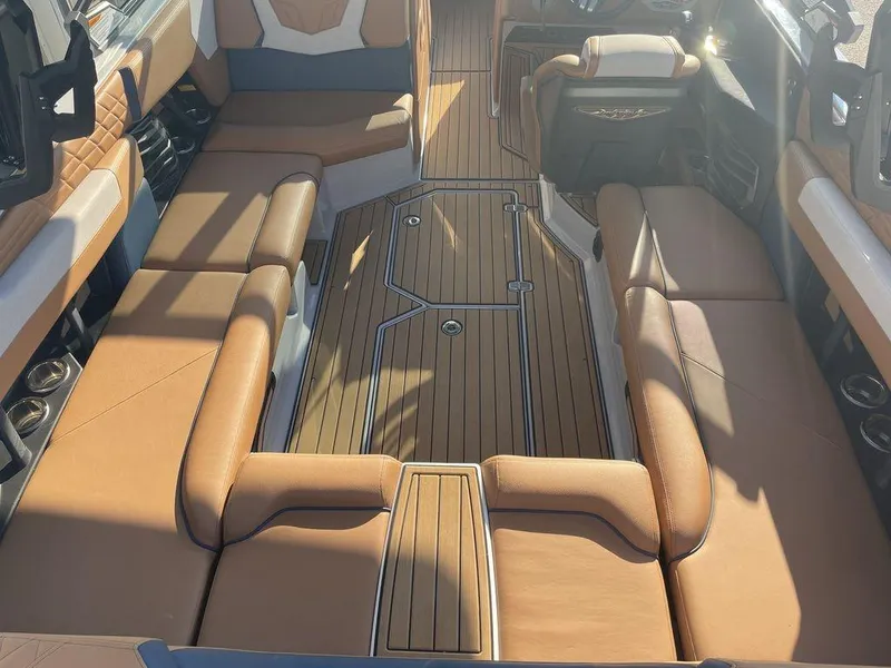 Slide: The Image of 2022 Nautique Super Air Nautique G23 interior with luxurious seating and teak flooring. - 5