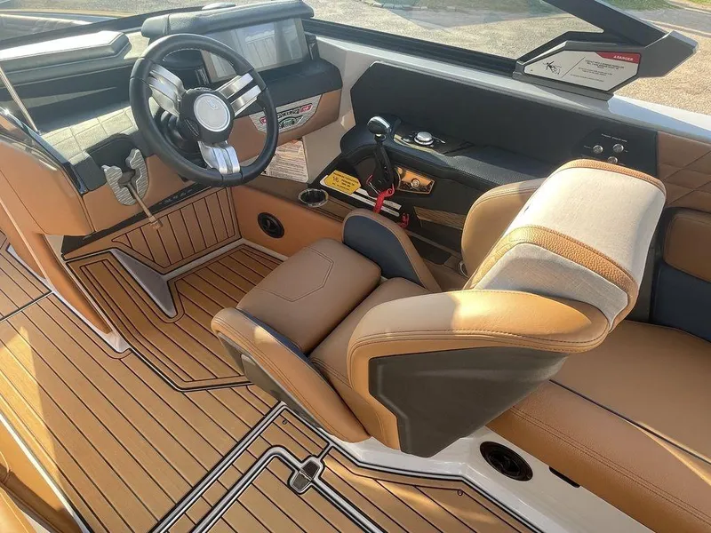 Slide: The Image of 2022 Nautique Super Air Nautique G23 interior with tan leather seats and modern steering wheel. - 7