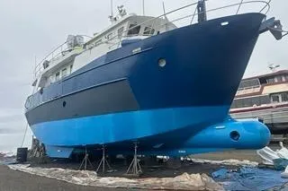 Slide: The Image of 2000 Cape Horn Trawler on dry dock, blue hull, maintenance underway. - 63