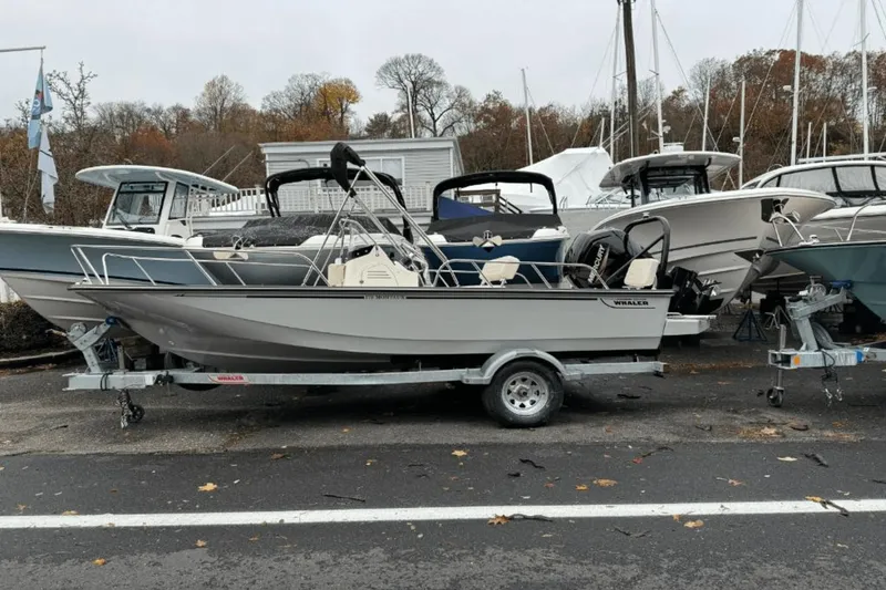 Slide: The Image of 2024 Boston Whaler 170 Montauk boat on a trailer, parked in a marina. - 1