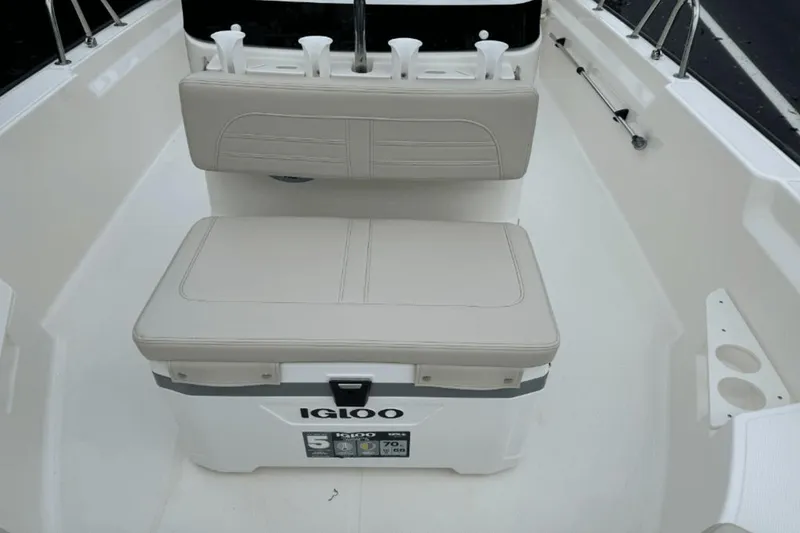 Slide: The Image of 2024 Boston Whaler 170 Montauk boat interior with Igloo cooler and cushioned seating. - 14