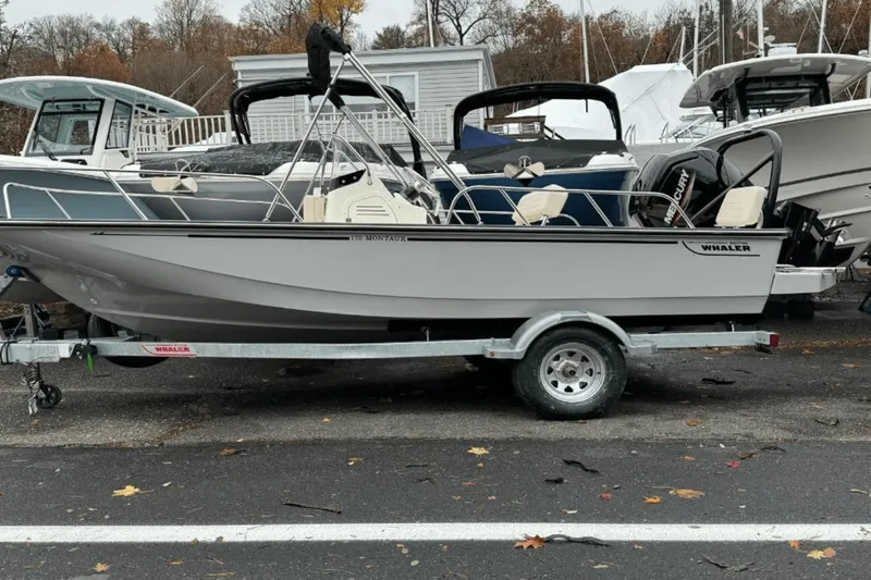 Slide: The Image of 2024 Boston Whaler 170 Montauk boat on a trailer, parked in a marina. - 3