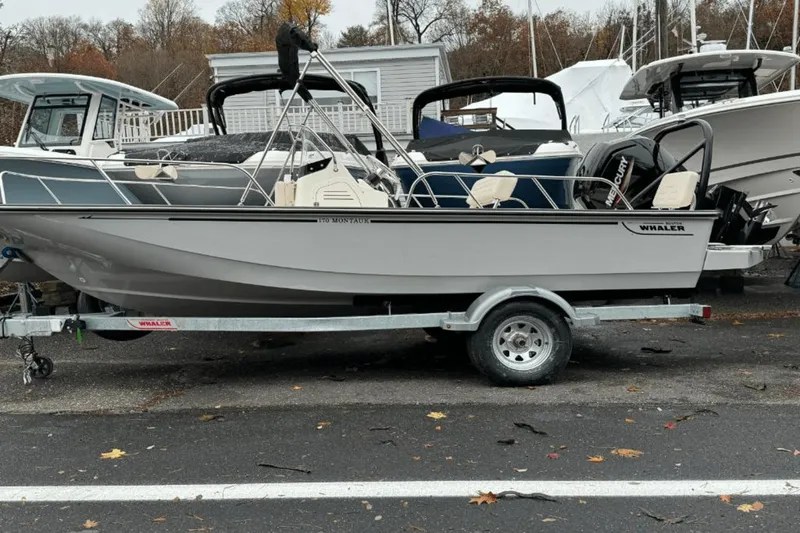 Slide: The Image of 2024 Boston Whaler 170 Montauk boat on a trailer, parked outdoors. - 4