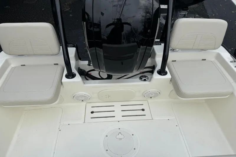 Slide: The Image of 2024 Boston Whaler 170 Montauk boat interior with cushioned seating and motor. - 6