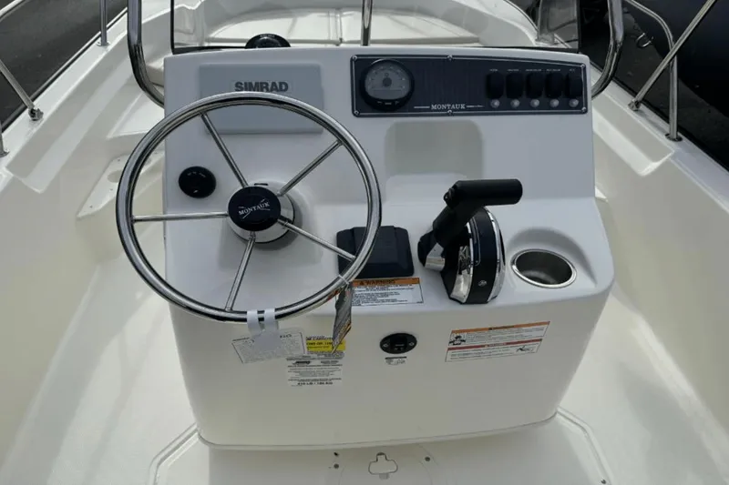Slide: The Image of 2024 Boston Whaler 170 Montauk boat console with steering wheel and controls. - 9