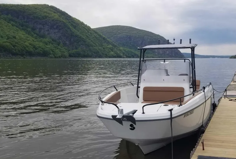 Slide: The Image of 2020 Beneteau Flyer 8 SPACEdeck boat docked on a scenic lake with lush hills. - 2