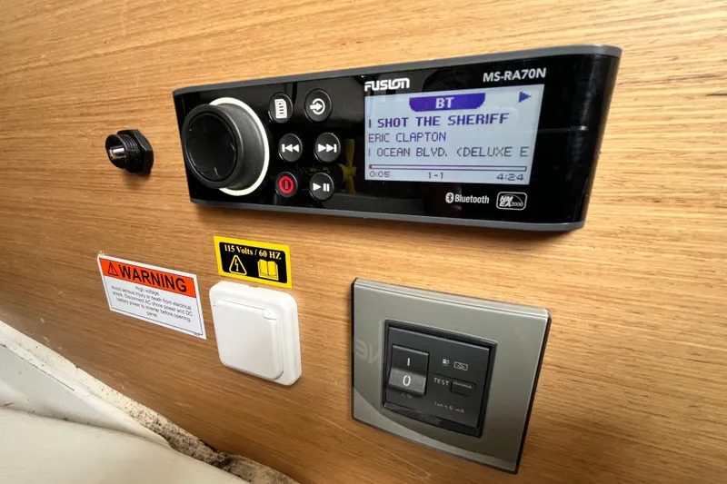 Slide: The Image of Control panel on a 2020 Beneteau Flyer 8 SPACEdeck with music display and warning labels. - 30
