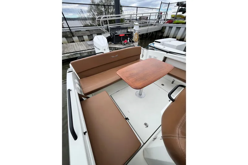 Slide: The Image of 2020 Beneteau Flyer 8 SPACEdeck with brown seating and wooden table, docked by the water. - 44