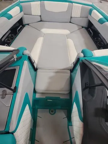 Slide: The Image of 2023 Malibu M220 boat interior with teal and white seating. - 6