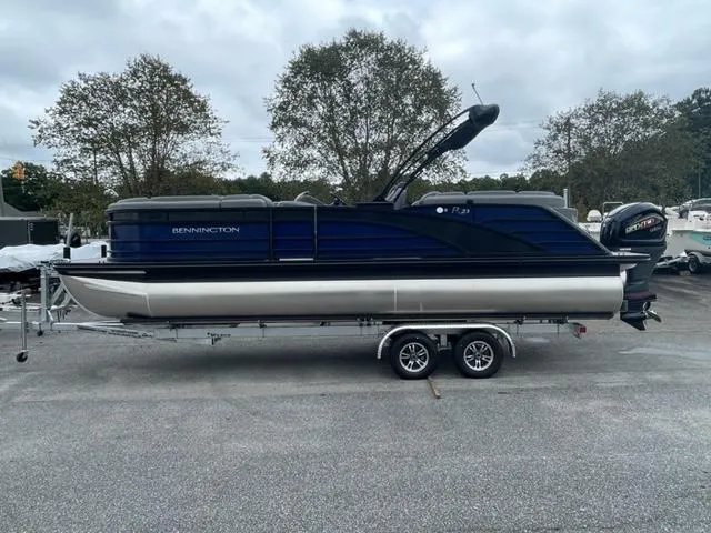 Slide: The Image of 2023 Bennington 23R pontoon boat on trailer, parked outdoors. - 4