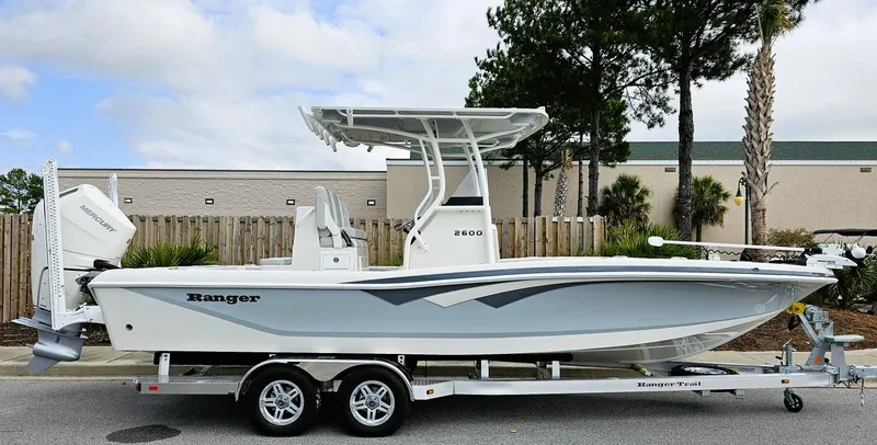 The Image of 2024 Ranger 2600 Bay boat on trailer, side view, white hull, outdoor setting. - 0