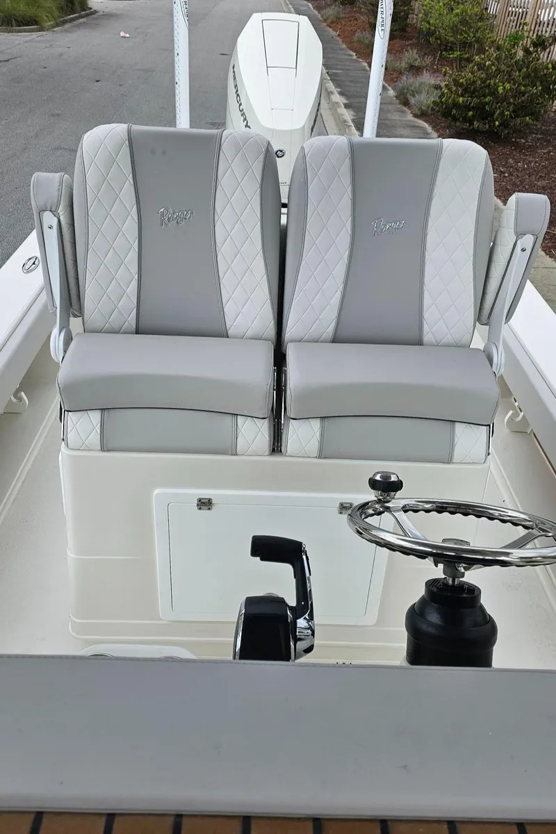 Slide: The Image of 2024 Ranger 2600 Bay boat with dual cushioned seats and steering wheel. - 21