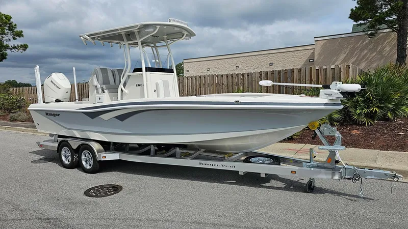 Slide: The Image of 2024 Ranger 2600 Bay boat on a trailer, parked outdoors. - 9