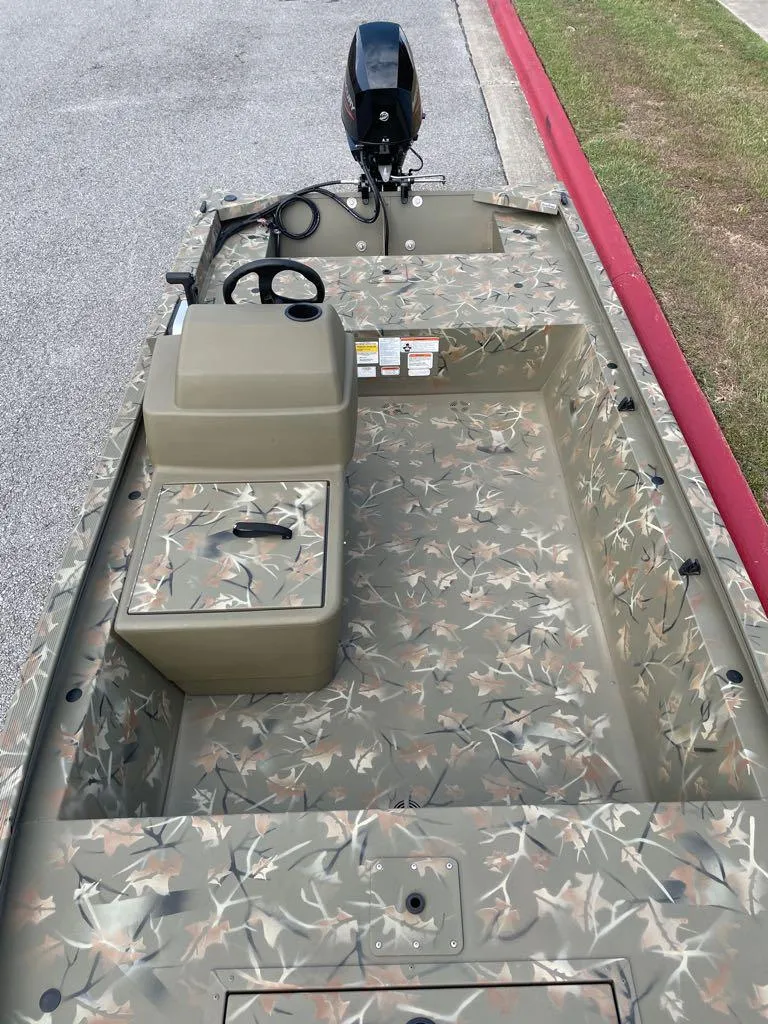 Slide: The Image of 2024 Tracker Grizzly 1648 SC boat with camouflage interior and outboard motor. - 3