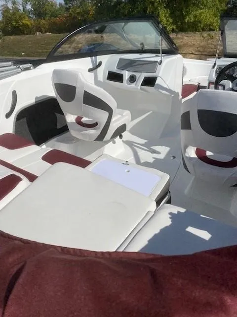 Slide: The Image of 2024 Tahoe 185 S boat interior with white and maroon seating. - 2