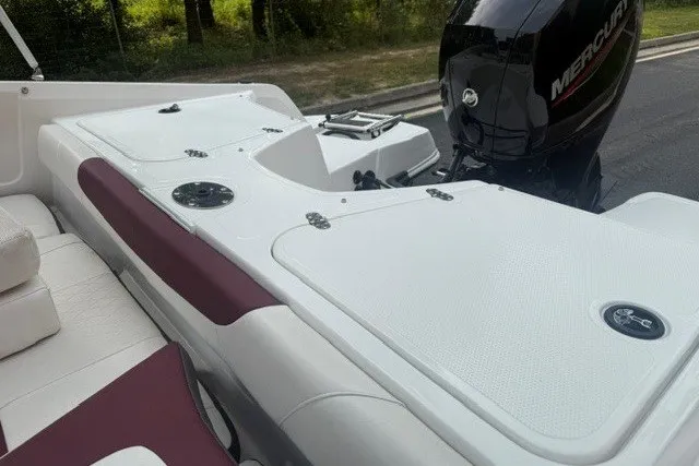 Slide: The Image of 2024 Tahoe 185 S boat interior with Mercury engine, featuring white and maroon seating. - 13