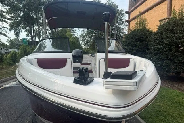 Slide: The Image of 2024 Tahoe 185 S boat with maroon and white interior, parked outdoors. - 4