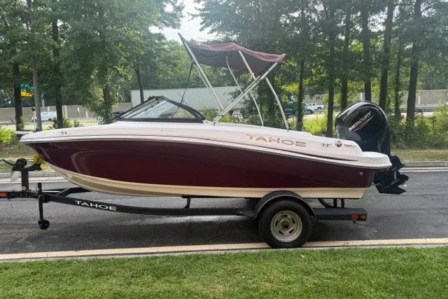The Image of 2024 Tahoe 185 S boat on trailer, parked outdoors with trees in the background. - 0