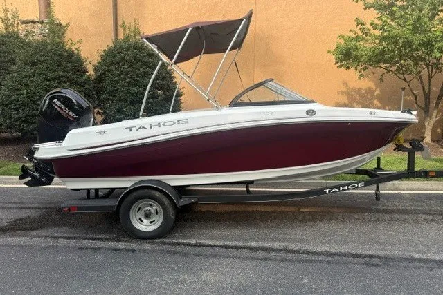 Slide: The Image of 2024 Tahoe 185 S boat on trailer, maroon and white design, parked outdoors. - 1