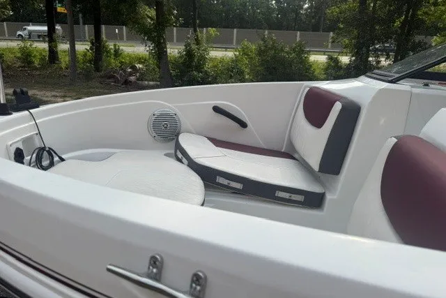 Slide: The Image of 2024 Tahoe 185 S boat interior with white and maroon seating, speaker, and wooded backdrop. - 14