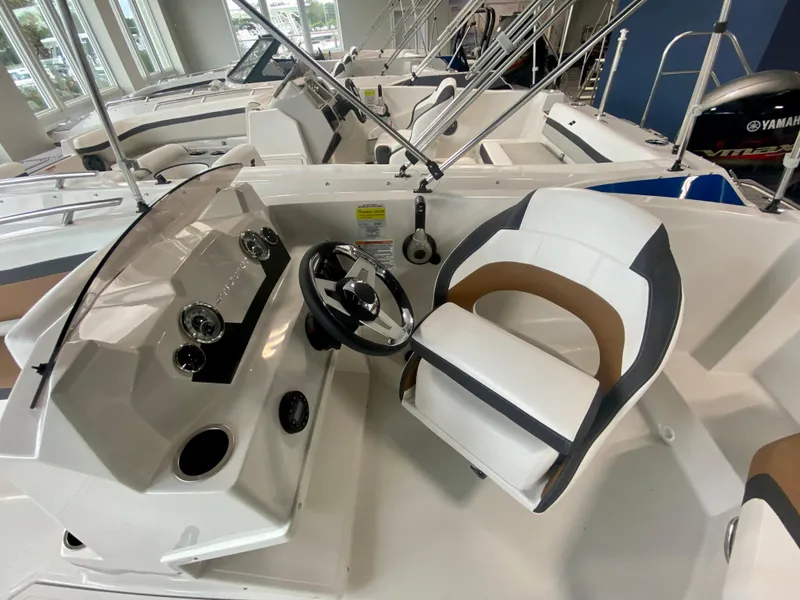 Slide: The Image of 2026 Starcraft SVX 171 boat interior with steering wheel and seating in showroom. - 11
