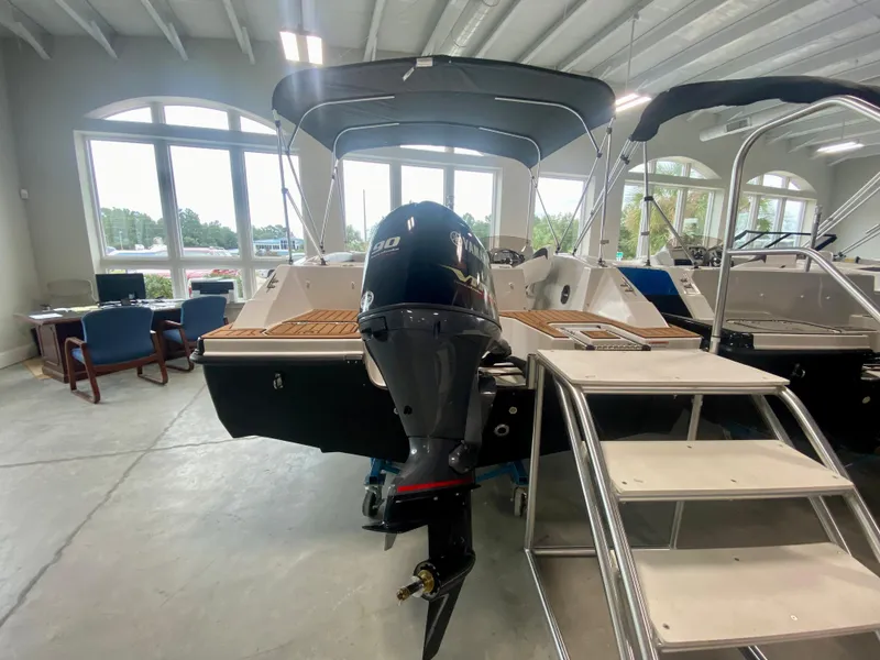 Slide: The Image of 2026 Starcraft SVX 171 boat with outboard motor in showroom, featuring sleek design and modern amenities. - 2