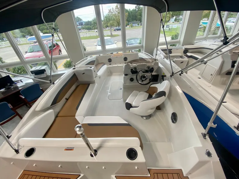 Slide: The Image of 2026 Starcraft SVX 171 boat interior with seating, steering wheel, and modern design in showroom. - 4