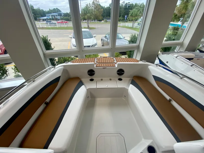 Slide: The Image of 2026 Starcraft SVX 171 boat interior with tan and black seating, docked indoors. - 14