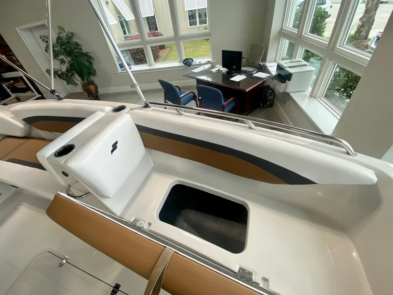 Slide: The Image of 2026 Starcraft SVX 171 boat interior with seating and storage, displayed in a showroom. - 15