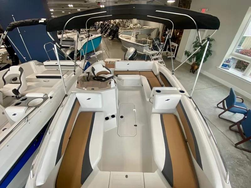 Slide: The Image of 2026 Starcraft SVX 171 boat with sleek interior and canopy in showroom. - 20