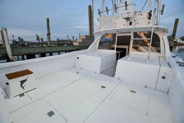Slide: The Image of 1965 Bertram Sportfisher boat with spacious deck at a marina. - 10