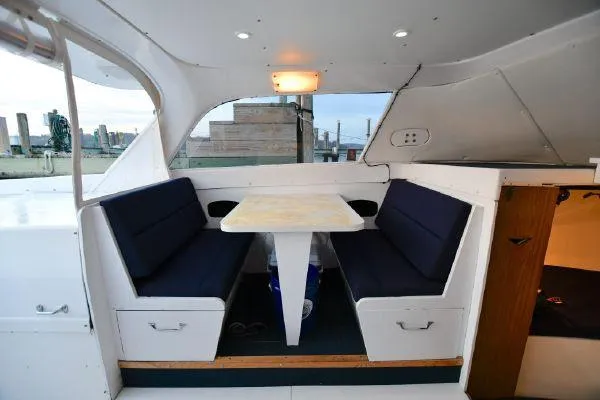 Slide: The Image of 1965 Bertram Sportfisher interior with dining area and blue cushioned seating. - 19