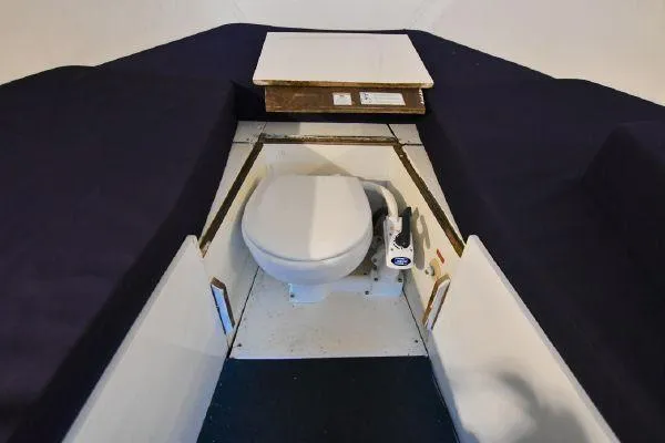 Slide: The Image of 1965 Bertram Sportfisher interior with marine toilet and seating area. - 22