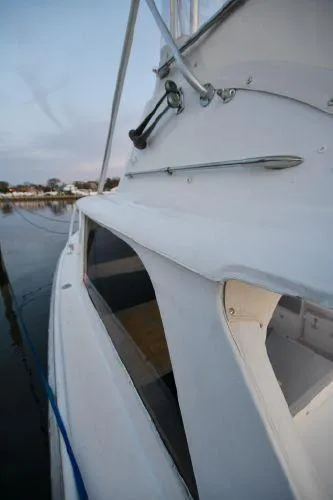 Slide: The Image of 1965 Bertram Sportfisher boat docked, showcasing sleek white exterior design. - 28