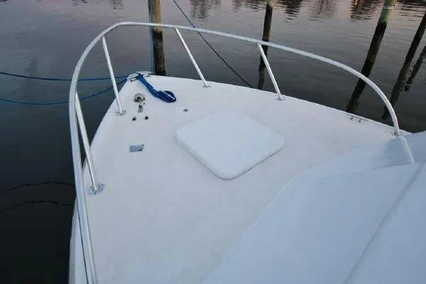 Slide: The Image of 1965 Bertram Sportfisher boat deck with railing, docked on calm water. - 29